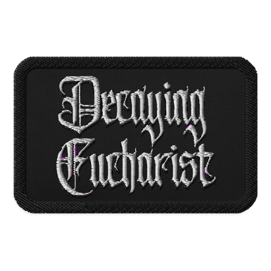 The Decaying Eucharist "Logo" Embroidered Patch by Mainstay Entertainment is a black rectangular patch featuring ornate white gothic lettering and subtle purple accents.