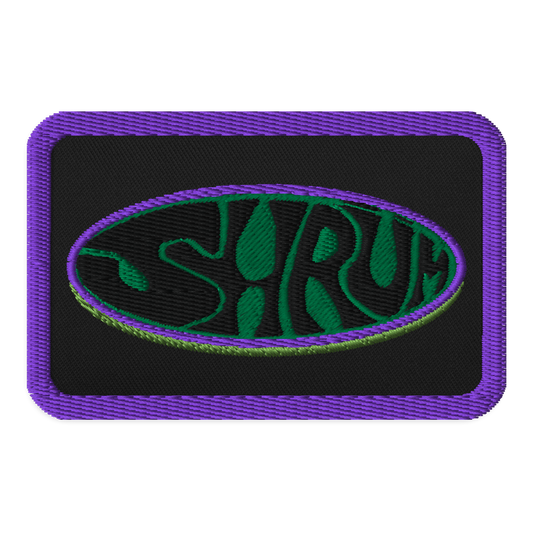 The SHRÜM "Logo" Embroidered Patch by Mainstay Entertainment is a rectangular patch with a purple border, black background, and an oval outlined in green and purple featuring "SHRUM" in bold wavy green-black letters. Iron-on or sew-on.