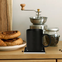 A black mug rests on a Mainstay Entertainment Flesh Parade 