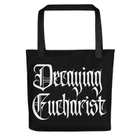 The Decaying Eucharist "Logo" Tote Bag by Mainstay Entertainment features bold white gothic lettering on the front and two black handles, offering a spacious and stylish way to carry your essentials.