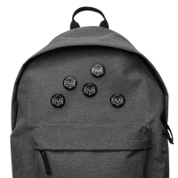 A gray backpack adorned with Mainstay Entertainment's False Gods "Snake Logo" set of 5 buttons, each featuring bold white FALSE GODS text in all caps.