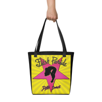 A hand holds the Flesh Parade "Dirty Sweet" Tote Bag by Mainstay Entertainment, featuring a pink star, a black woman’s silhouette, and “Flesh Parade” and “Dirty Sweet” text on a yellow background with radiating lines.
