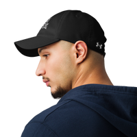 A man in a navy hoodie looks to the side, wearing the Flesh Parade "Embroidered Logo" Under Armour® Hat, featuring a white logo on the front. The plain white background highlights this versatile workout accessory.