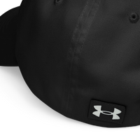 Close-up of the back of the black Flesh Parade "Embroidered Logo" Under Armour® Hat, showing a white embroidered logo on a black fabric patch near the bottom edge and a HeatGear sweatband for workout comfort.
