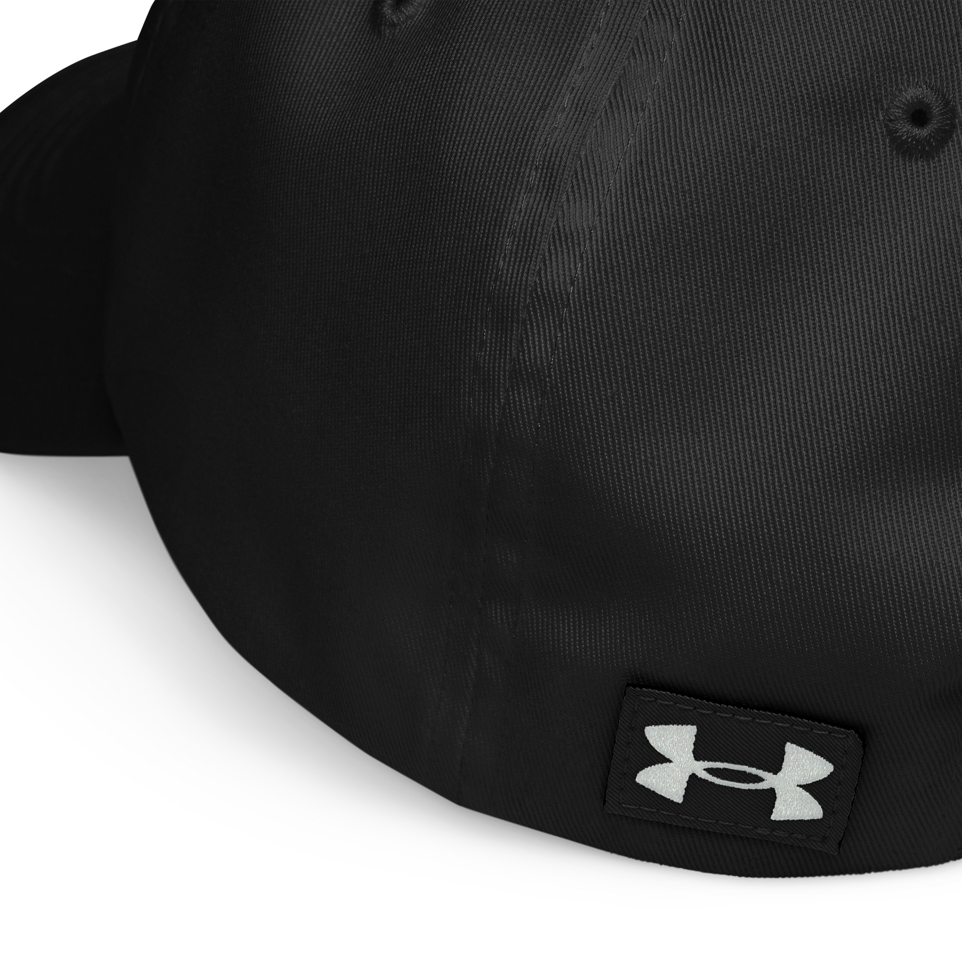 Close-up of the back of the black Flesh Parade "Embroidered Logo" Under Armour® Hat, showing a white embroidered logo on a black fabric patch near the bottom edge and a HeatGear sweatband for workout comfort.