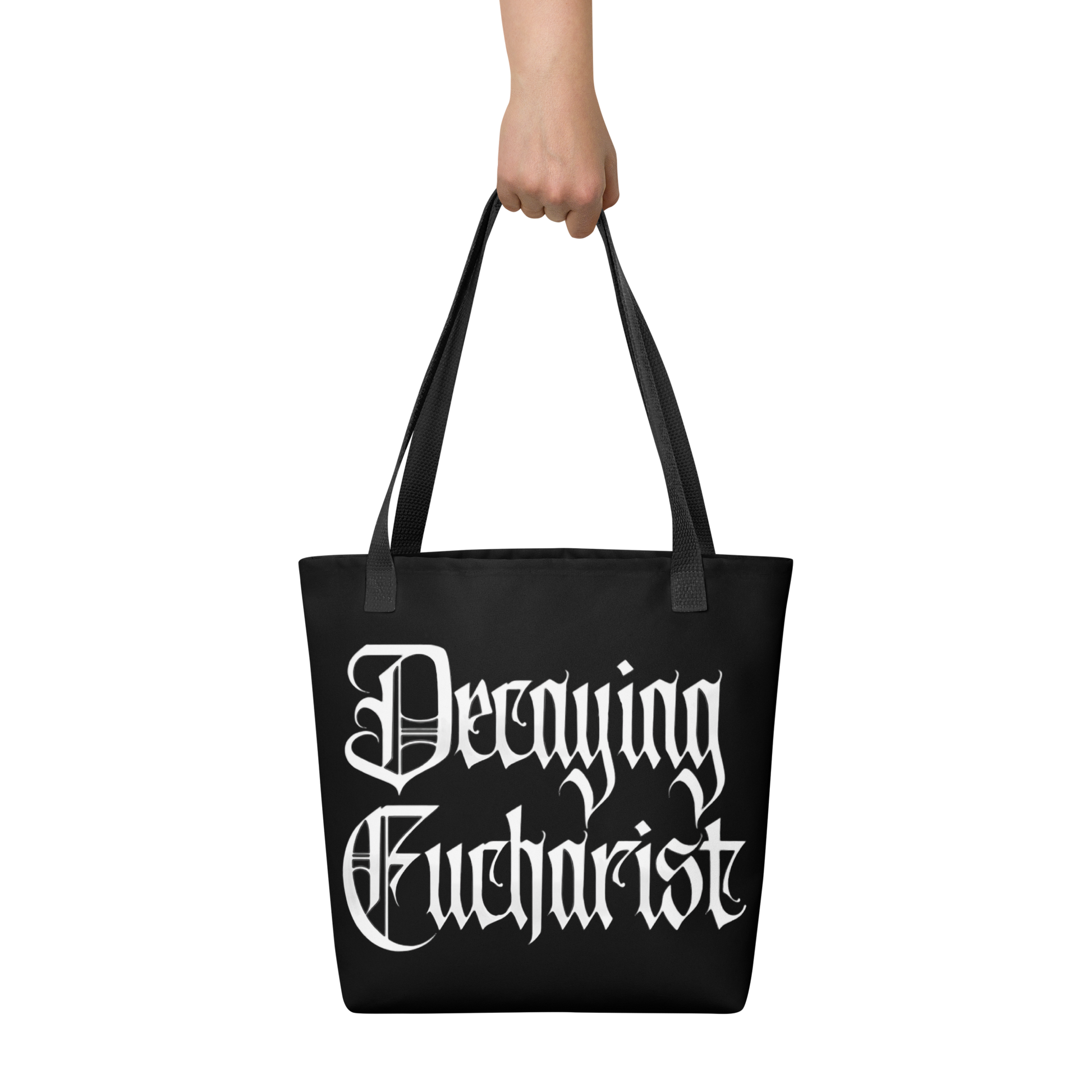 A hand holds the Decaying Eucharist "Logo" Tote Bag by Mainstay Entertainment, featuring large white gothic lettering.