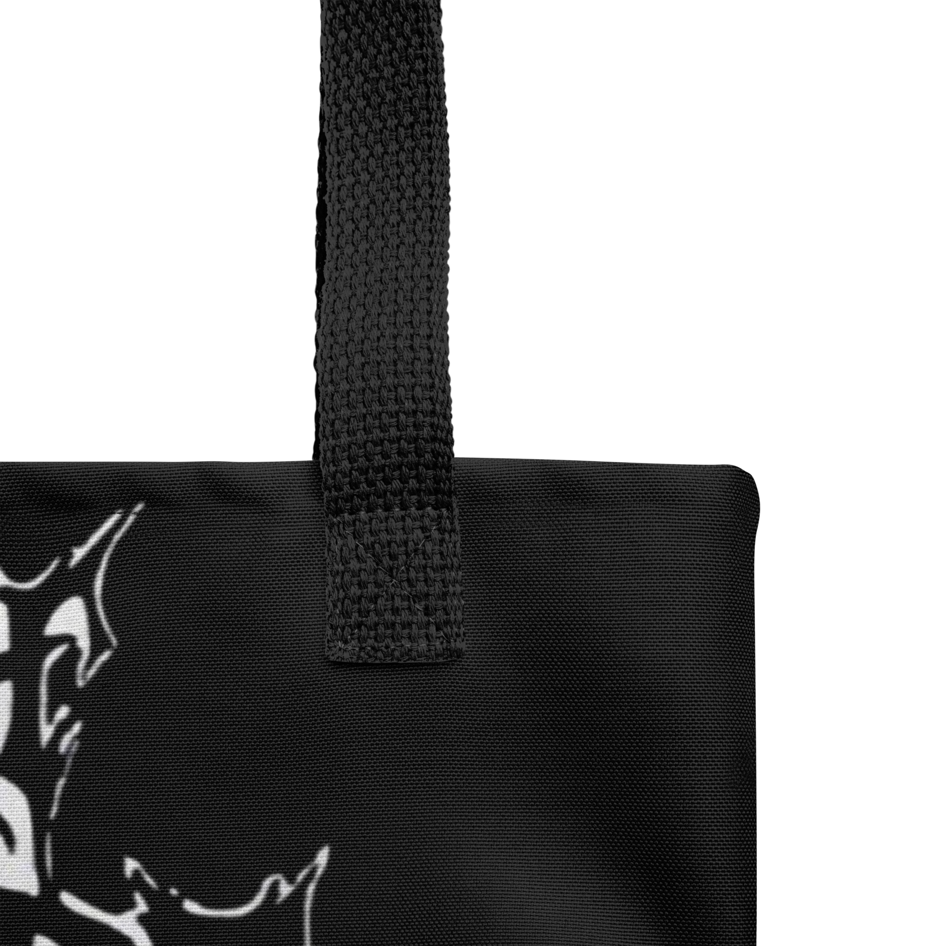 Close-up of the Flesh Parade "Meathook" Tote Bag V1 by Mainstay Entertainment in black fabric with a sturdy textured handle and part of a white abstract graphic on the left, set against a plain white background.