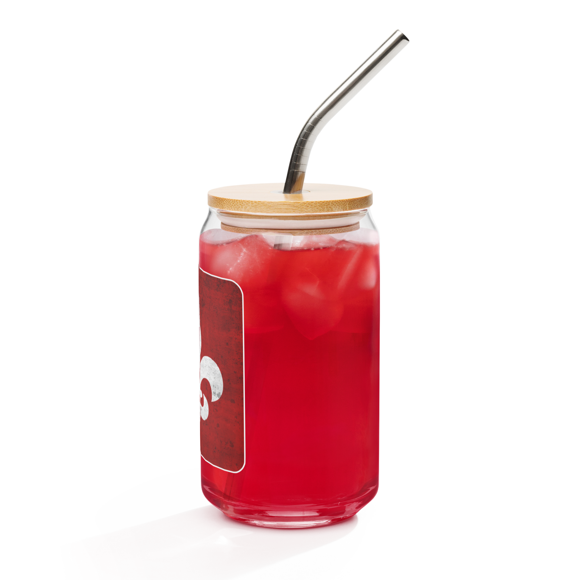 A Mainstay Entertainment "Fleur de Lis" can-shaped glass (16 oz) filled with a red iced drink, topped with a bamboo lid and metal straw, is set against a white background. The glass features a rectangular label with red and white accents.