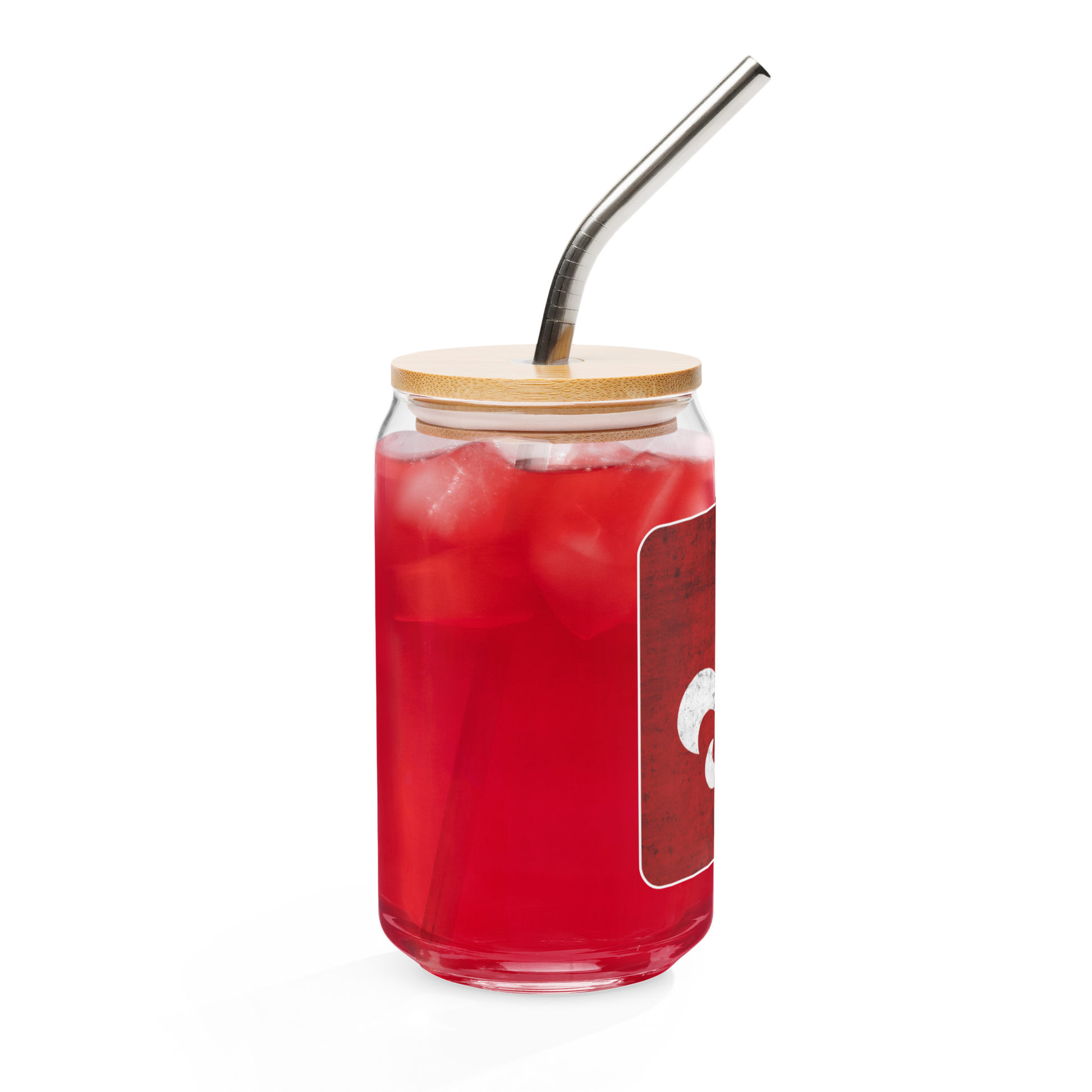 The Mainstay Entertainment "Fleur de Lis" Can-Shaped Glass (16 oz) holds a red iced drink, topped with a bamboo lid and metal straw. Its partially visible red and white label stands out against a plain white background.
