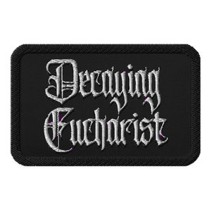 The Decaying Eucharist "Logo" Embroidered Patch by Mainstay Entertainment is a black rectangular patch featuring ornate white gothic lettering and subtle purple accents.