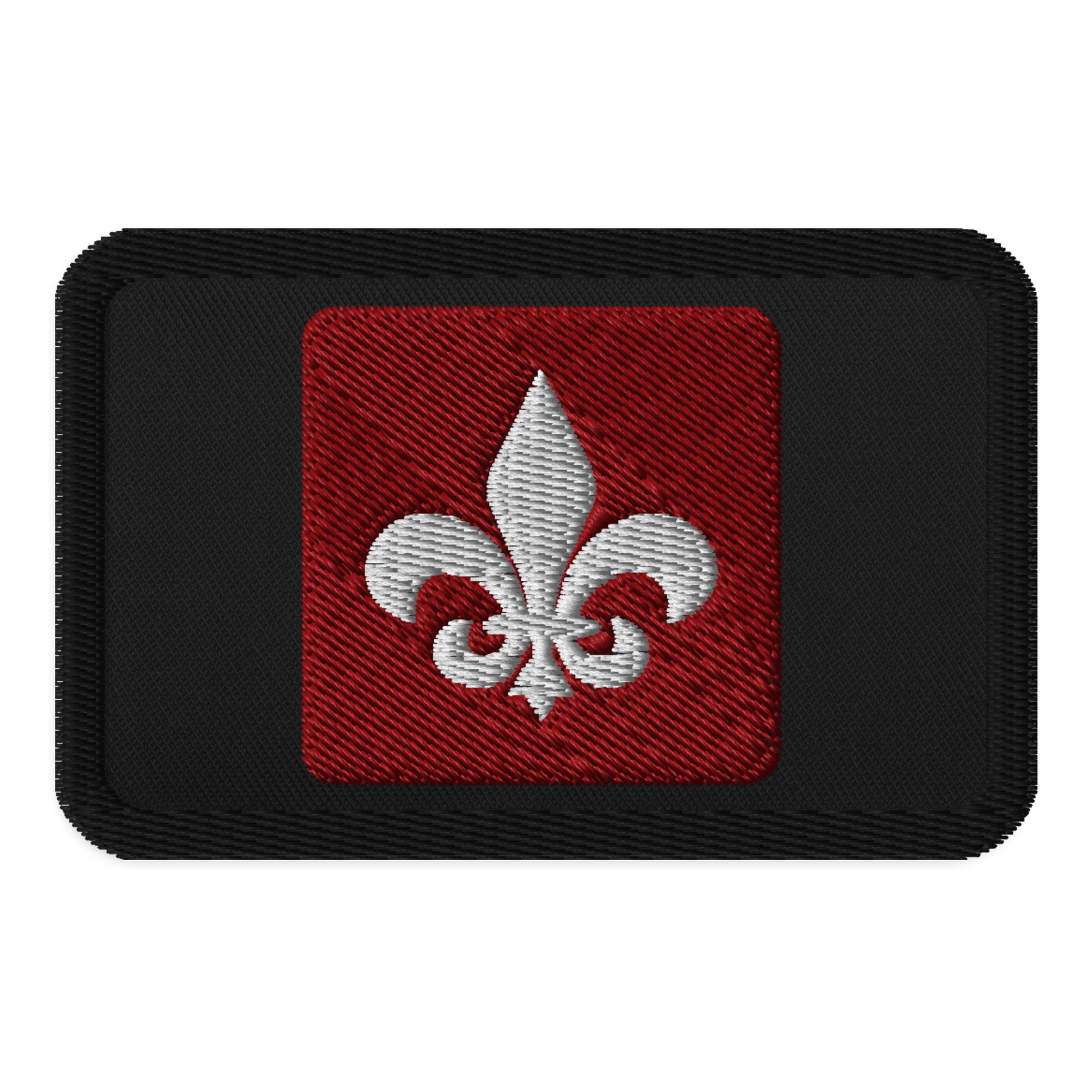 The Mainstay Entertainment "Fleur de Lis" Embroidered Patch is a black rectangular iron-on patch with a red square center and a white embroidered fleur-de-lis symbol.