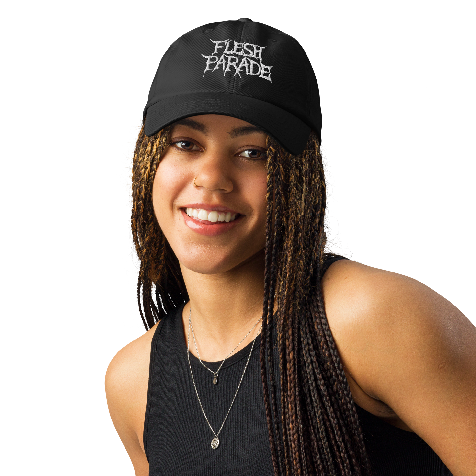 A smiling woman with long braids wears a black tank top and the Flesh Parade "Embroidered Logo" Under Armour® Hat, featuring white lettering, against a plain light background.