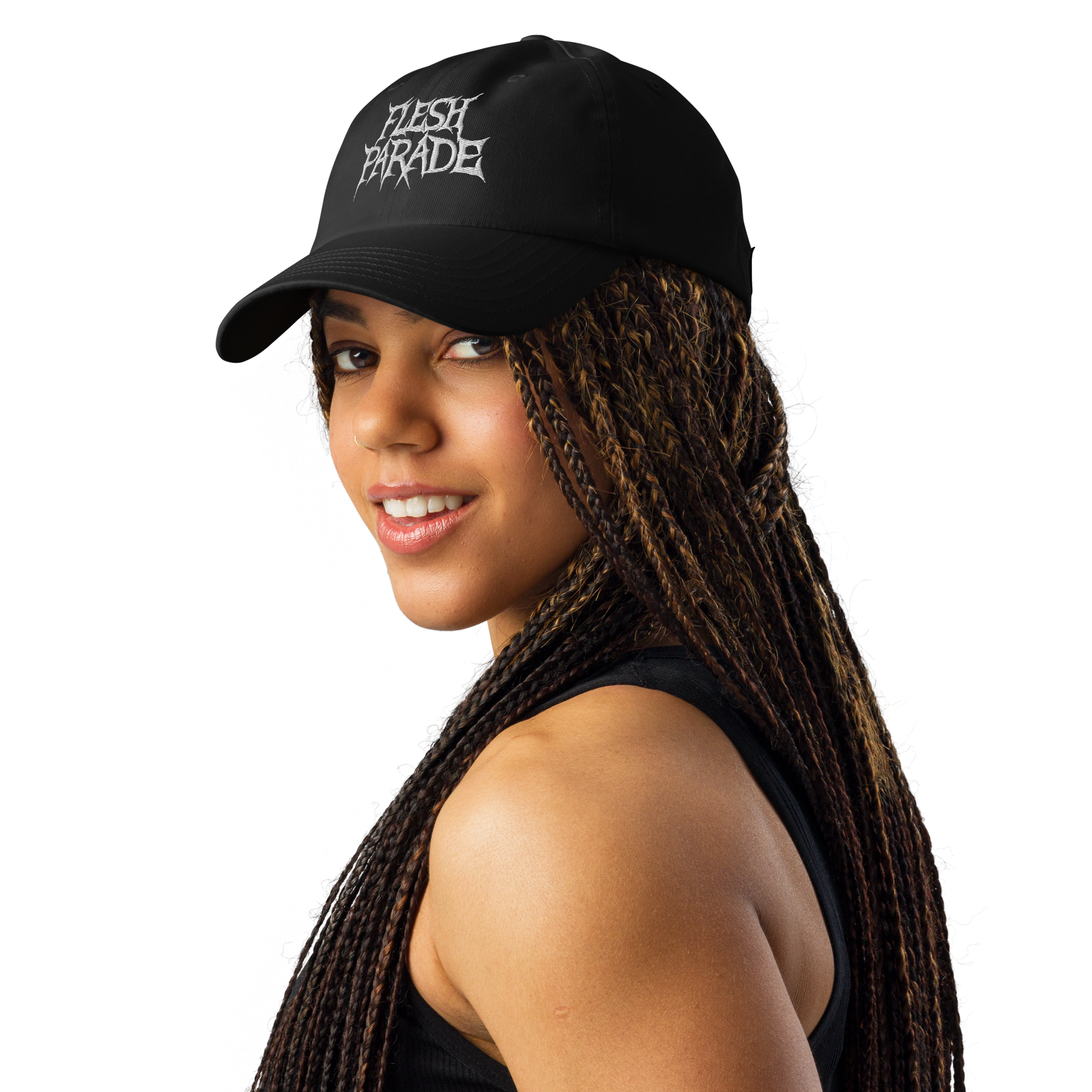 A woman with long braided hair wears the Flesh Parade "Embroidered Logo" Under Armour® Hat, featuring white text and a HeatGear sweatband, along with a black sleeveless top. She smiles while looking over her shoulder against a white background.
