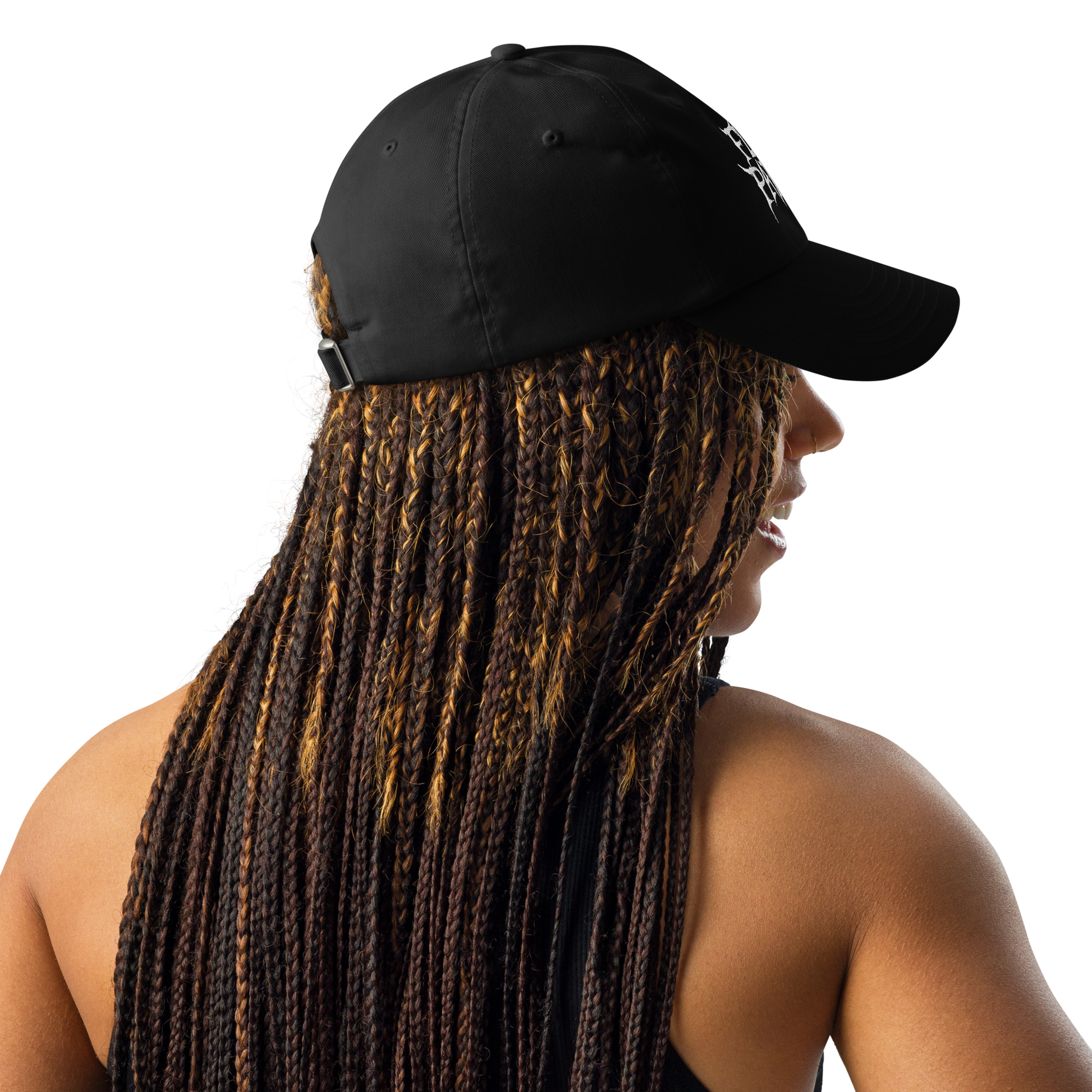 A woman with long braids wears the Flesh Parade "Embroidered Logo" Under Armour® Hat in black and a sleeveless top, seen from the back and slightly to the side against a plain white background.